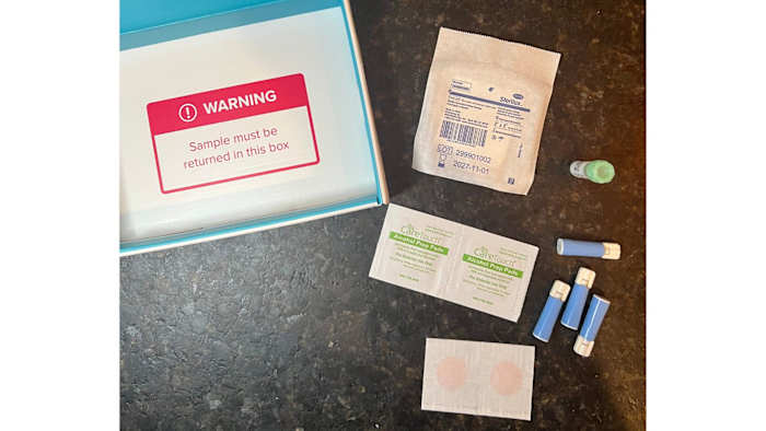 Parts of the LetsGetChecked Thyroid test kit, including four lancets, a sample collection vial, alcohol wipes, gauze and two bandaids.